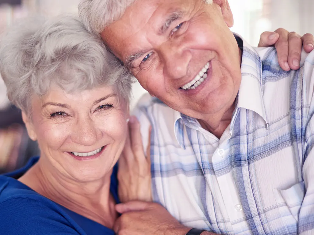 Glückliches Seniorenpaar lächelt in die Kamera