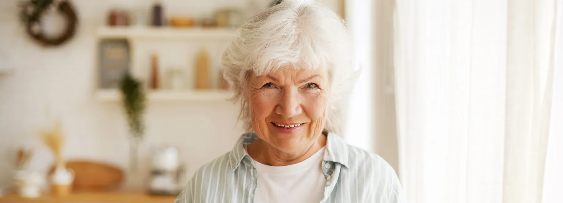 Ältere Frau lächelt in die Kamera. Es geht um die Verwendung von Premiumlinsen.
